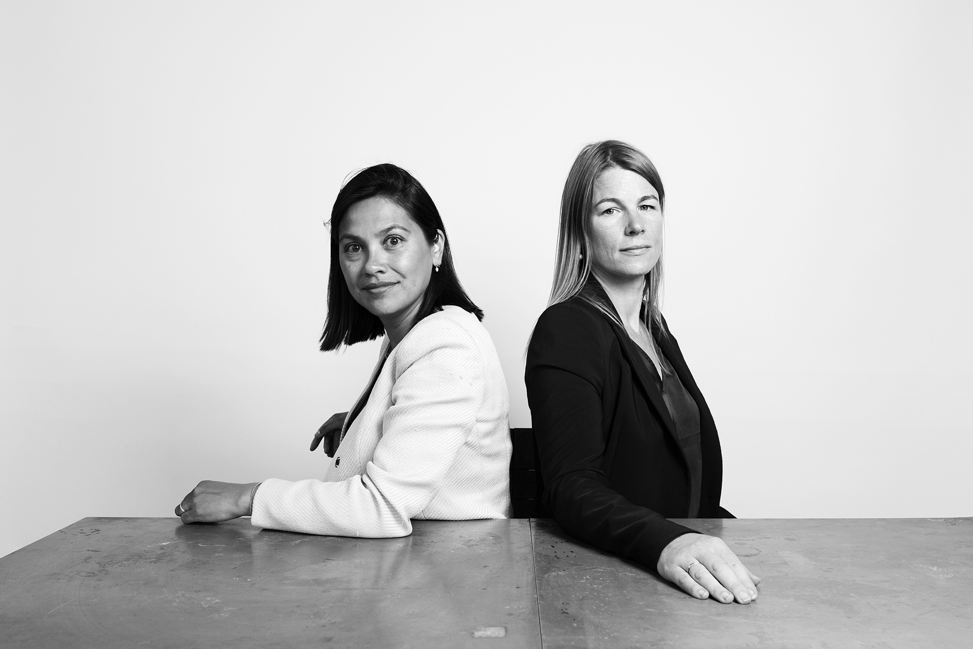 The founders of The Board Whisperers behind a table during a strategy session, black-and-white photograph