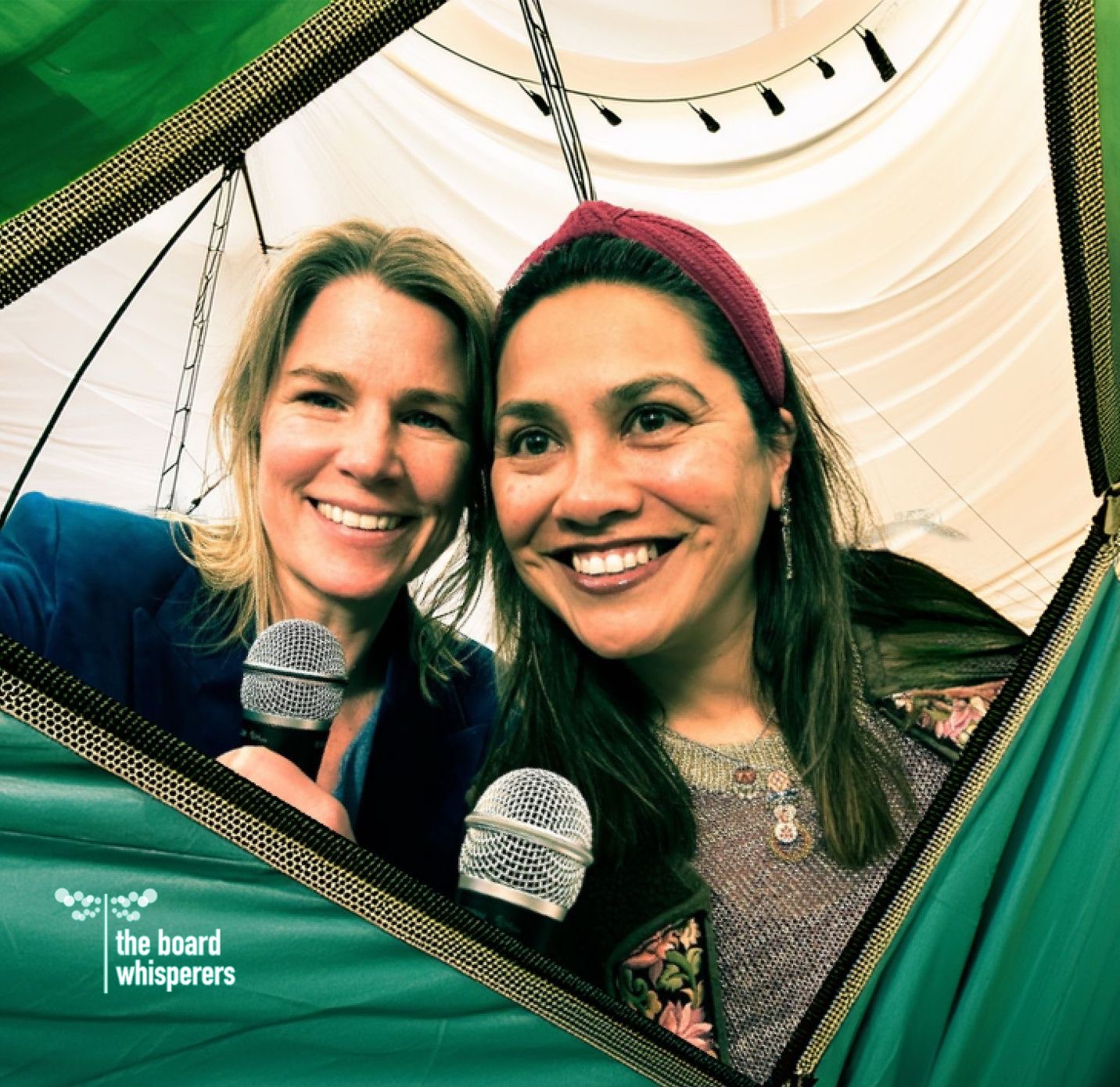 Microphones in hand at a festival tent.